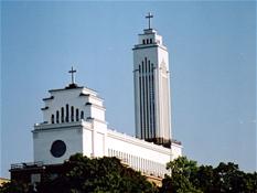 <p style="text-align: justify;">In 1922, Kaunas, the former temporary capital of Lithuania, gave rise to the idea to build the Monumental Christ's Resurrection Church, which, as a symbol of national revival, had to embody "long suffering and strenuous fights of our nation, in particular our greatest achievement - the revival of the independent state". In 1926, the council of construction and the executive committee, as well as their statutes were registered. The honorary chairmen of the council and the committee were elected the archbishop of Kaunas Juozas Skriveckas and the President of the Republic of Lithuania Antanas Smetona respectively; the rector of Žaliakalnis Church priest Feliksas Kapočius was appointed the chairman of the executive committee. In 1928, the municipal government gave a parcel of land in Žaliakalnis neighbourhood, near Žemaičių street.    </p>
<p style="text-align: justify;">The church design competition announced the same year requested that the church would be designed "at the discretion of the author but it should preferably characterise the peculiar qualities of the spirit of Lithuania and be linked with its honourable past and the fight for independence, and its exterior view should by itself be a monument to that fight...". In fact, as soon as the idea was shaped, quite a large group of opponents to both improper urbanistic location (lack of communication with the lower part of the city) and the very idea of the church emerged: "The monument of independence should be the monument of the entire nation, without reference to religion, language and political views." Proposals were brought forward to replace the church by a monument To the Unknown Book Smuggler, museum, etc. Nevertheless, the competition was announced in 1928. Out of 15 projects, prizes were awarded to three of them. The first prize went to Jonas Krasauskas, the second was given to Feliksas Vizbaras, and the third was awarded to Karolis Reisonas. However, it was decided that "none of them is consistent with the monument idea" and "after discussing it with certain professional architects and well-known public figures" the construction of the church was assigned to Karolis Reisonas, who made considerable changes to his competition project by creating a spectacular reinforced-concrete 83 m-high spiral-pyramid volume, which was to be crowned with a giant "7 m high statute of Christ's Resurrection". It was believed that the building "will give a character to Kaunas, like the Eiffel Tower does to Paris".           </p>
<p style="text-align: justify;"> Nevertheless, the project became the target for vigorous debate and protests in the press of that time. The most active opponents were the art historian Halina Kairiūkštytė-Jacynienė, Balys Sruoga, V. Kudirka Society who saw "platform-type style", "profane character" and the "creative incapacity" of the Lithuanian nation in the church design. Hence, even though the collection of donations to the said project began, long debates and "the impaired economic state of the country" made to refuse the impressive sculptural project, and in 1933 the final, far more ascetic, solution more modest in scope (according to the first project, the church accommodated 5,000 believers, whereas the second was designed for 3,000 people; also, the height of the great tower reduced to 70 m) and rather close to modernism style was prepared. Nevertheless, even if reduced in scope, the church was designed as the largest in the Baltic countries and had to remain the pantheon of the nation.</p>
<p style="text-align: justify;">Reinforced concrete poles (25x25, 3.5-6.5 m long) chosen for the foundations of the church were "for the first time applied on such a broad scale in Lithuanian civil engineering". 900 of such poles were used. The walls feature a reinforced concrete framework with brick filling. The ceiling is flat and "made of tall reinforced concrete beams with reinforced concrete masonry among them, cascade-shaped, which will not only create a certain architectural view but will serve as a very strong framework". Apart from a flat roof which is the key citation in the architectural language of international modernism, there were plans to use a symbolic sign of modernism - bright electrical lamps: "on the major holidays the great church tower will be illuminated with energy-intensive electrical lamps which will spread the rays of light across far-reaching environs". Even if the building is far simpler compared to the original project, the representative function of the church as "the sanctuary of the nation" was to be highlighted by various decorative solutions: "the great altar of the church will be like an ark of the covenant of the Lithuanian nation with God a giant painting will be behind the altar: Lithuanian old graves featuring leaning crosses with the <em>Vytis </em>- the revival of Lithuania - rising in the background of the reddish rays on the roof, the sculptural Way of the Cross with the bloody way of the cross of our nation next to them - the sufferings of Lithuanians for their faith and the freedom and independence of their country. Such a way of the cross will be the first in the entire Christian world," says the 1939 publication on the construction of the church.  </p>
<p style="text-align: justify;">Though in the beginning of construction processes it was optimistically believed that the church will cost some 3-5 million litas, one third of which would be financed from the state and the other share would be collected in donations and the work would be completed in 3-4 years, even when the estimate for a new project was considerably reduced, the construction was not completed until the Soviet occupation. During the years of Nazi occupation, the church was turned into a paper warehouse. In 1952, the building was adjusted to a radio factory, and was only returned to the believers in 1988. "In 1989, the architect H. Žukauskas and the specialists from the Department of Reinforced Concrete Constructions of Vilnius Institute of Civil Engineering, led by Prof. A. Kudzys, prepared the church restoration project." However, construction works were completed in 2004 only. The final project was drawn up by the former long-year chief architect of Kaunas City Algimantas Sprindys. As it was planned in the interwar period, the cellarage housed a columbarium and a chapel.     </p>
<p style="text-align: justify;">Due to its scope, urban situation and political importance, the church is definitely the most significant example of sacred architecture of the interwar Lithuania. A moderate building, not overloaded with details, flat-roofed and modern-structured, features the intertwining international ideas of modernism and the interpretations of local forms. One of the key aesthetical solutions - a dense rhythm of vertical lines - is an obvious characteristic feature of a number of public objects of the interwar period in Kaunas.   </p>
<p style="text-align: justify;">P.S. <em>A part of the illustrations were taken from the Archive of Cultural Events and Publishing Group of the Kaunas County Public Library (KCPL). Travelling exhibition: Monumental Christ's Resurrection Church, 2003.</em></p>
<p style="text-align: justify;"><em>Vaidas Petrulis, Beata Brazdžionytė</em></p>